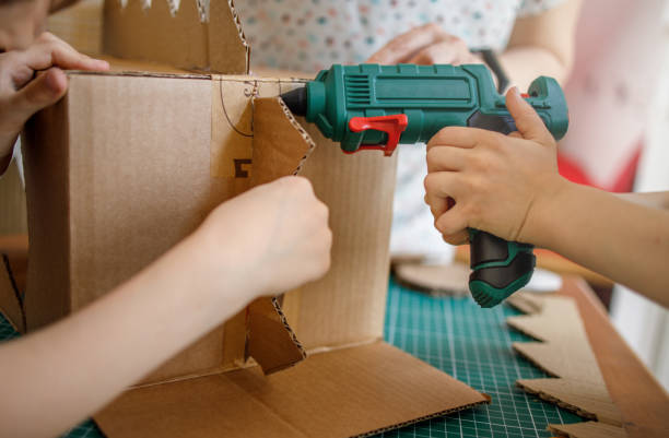 istock Mom and kids making a cardboard dinosaur costume 1223289897