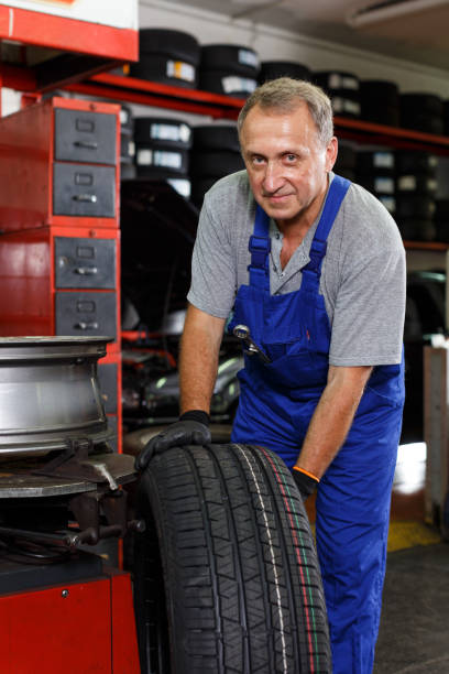 istock Mechanician removing tire from wheel disc 1223294524
