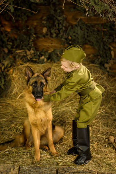 istock a boy stands with a shepherd in uniform. 1223296850