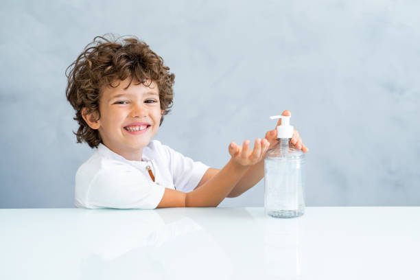istock Smiling child using hand sanitizer, alcohol gel for disinfection and prevention 1223297785
