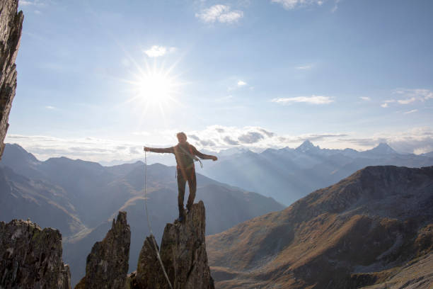istock Mountaineer climbs up rock pinnacle at sunset 1223301323