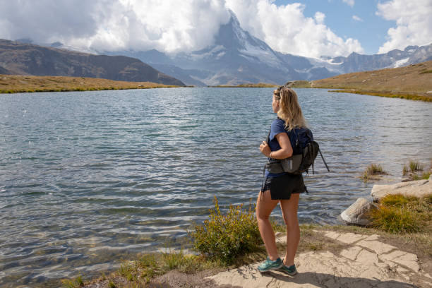 kobieta turystka zatrzymuje się nad brzegiem jeziora - hiking young women outdoors t shirt zdjęcia i obrazy z banku zdjęć