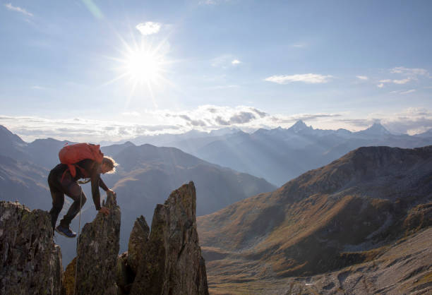 istock Mountaineer climbs up rock pinnacle at sunset 1223302031