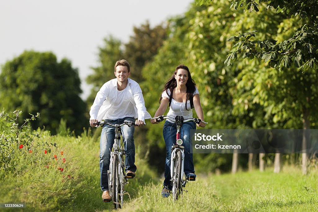 Мужчина и женщина, велоспорт В летнее - Стоковые фото Белый роялти-фри