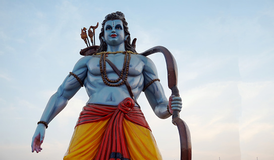 View of Hindu God Rama idol,with bow and arrows,against blue sky