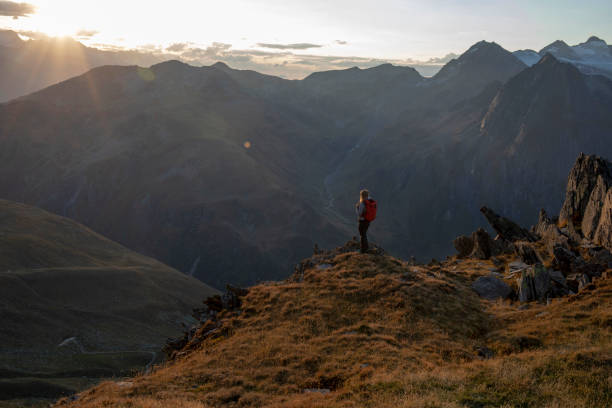 istock Female hiker relaxes on mountain ledge at sunset 1223306626