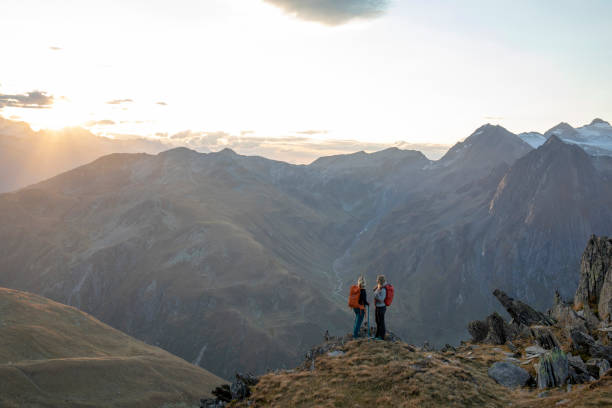 istock Female hikers relax on mountain ridge at sunset 1223307288