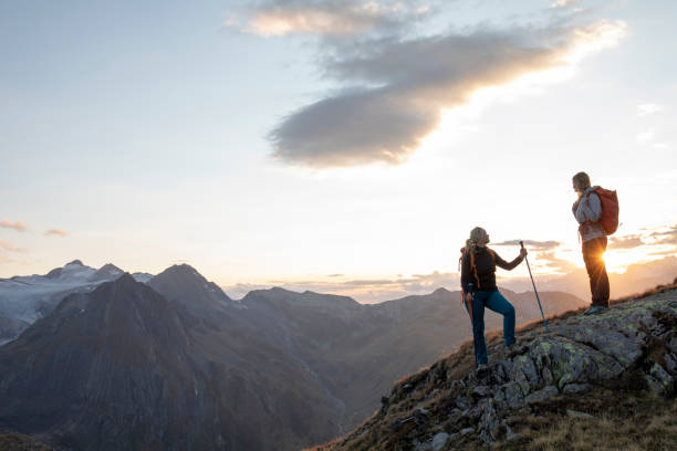 istock Female hikers relax on mountain ridge at sunset 1223307300