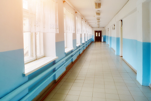 a public school, a long empty corridor with blue walls