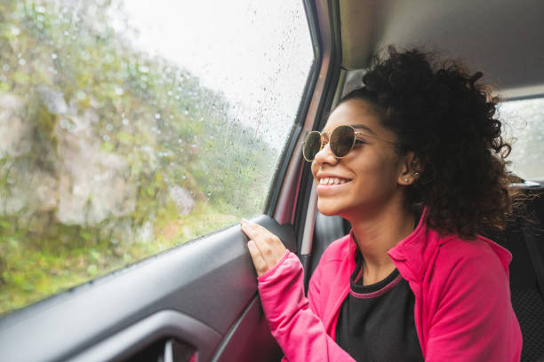 istock Smiling girl looking out the car window 1223308219
