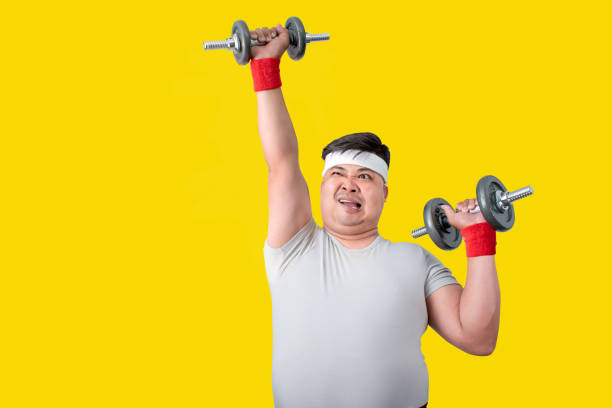 los hombres asiáticos con sobrepeso tienen la intención de hacer ejercicio con mancuernas levantadas para bajar de peso. concepto de atención médica. - intend fotografías e imágenes de stock