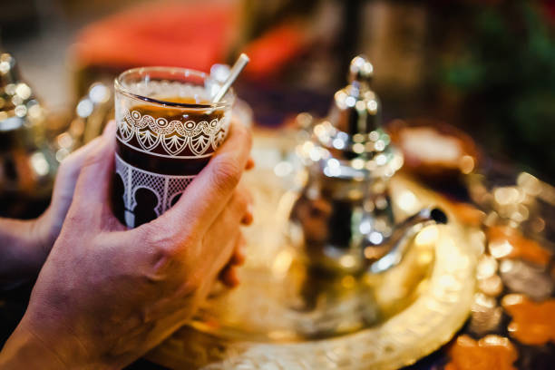 istock hands with traditional Arabic tea cup, arab people drinking tea in Ramadan 1223316020