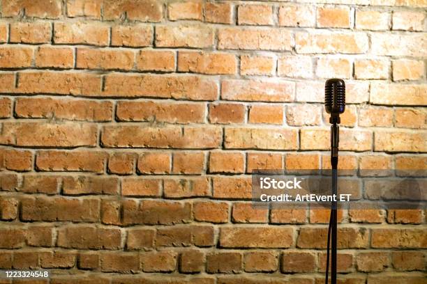 Microphone Ready On Stage Against A Brick Wall Stock Photo - Download Image Now - Microphone, Comedian, Open
