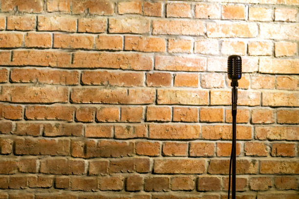 microphone ready on stage against a brick wall - comedian imagens e fotografias de stock