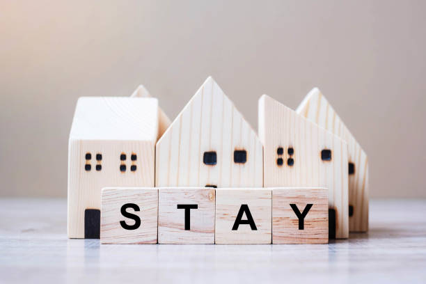 istock Wooden Cube blocks with STAY text and Home model on table background. Coronavirus, Covid-19, Quarantines and Social Distancing concept 1223324603
