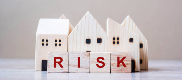 istock RISK cube blocks with wooden house model on table background. Coronavirus pandemic, fall Business, investment, Crisis, Economic recession, Developer, Real Estate and Property concept 1223324605