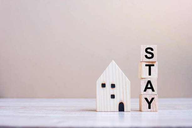 istock Wooden Cube blocks with STAY text and Home model on table background. Coronavirus, Covid-19, Quarantines and Social Distancing concept 1223324630