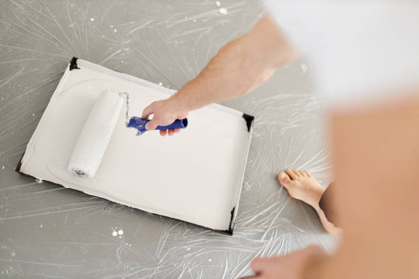 istock A middle-aged man paints paint on a wall in his house using a paint roller, paint bucket, paint and a ladder 1223324806