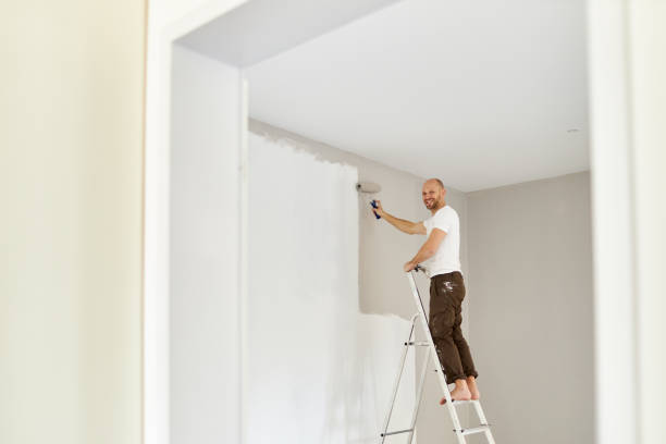 istock A middle-aged man paints paint on a wall in his house using a paint roller, paint bucket, paint and a ladder 1223325489