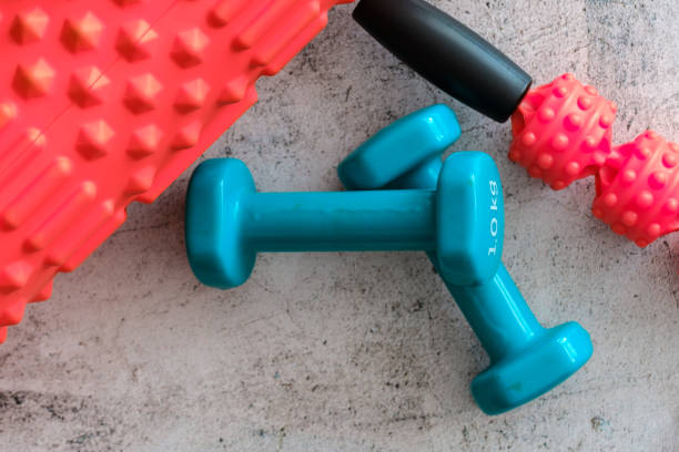 istock Two blue dumbbells with foam massage roller on white 1223327086