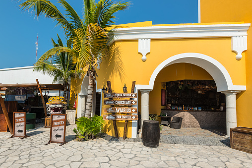 Costa Maya, Mexico - April 26, 2019: Street view at day with palm near bar and shops in Costa Maya, Mexico. Today the town is one of Mexican most top tourist destinations.
