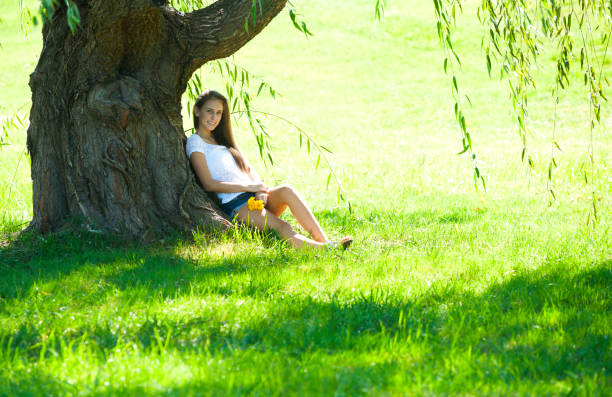 istock Pretty teen girl sitting under willlow tree 1223330742