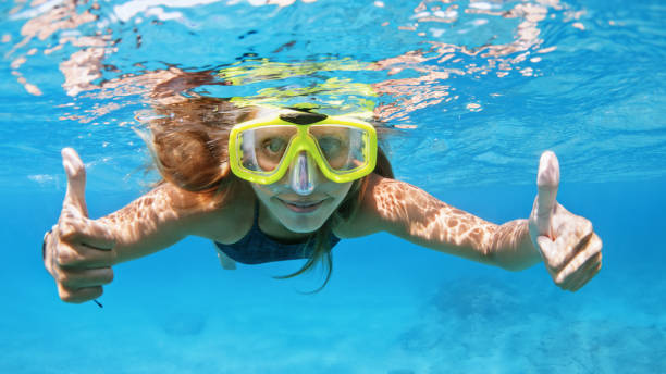 giovane donna in tuffo maschera snorkeling sott'acqua con pesci tropicali - maschera da subacqueo foto e immagini stock