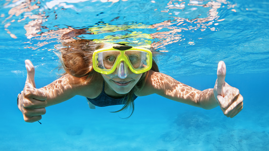 Happy family - active young woman in snorkeling mask dive underwater, see tropical fishes in coral reef sea pool. Travel adventure, swimming activity and watersports on summer beach cruise with kids.