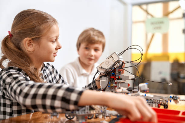 istock Boy and girl creating robot using building kit. 1223332395