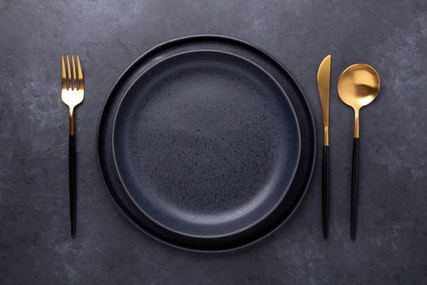 dark table setting. two empty ceramic plates and cutlery on stone background copy space for your text - table knife silverware black fork imagens e fotografias de stock