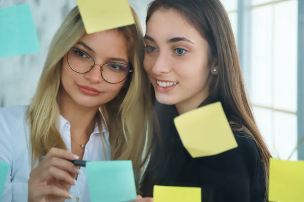 istock Two businesswomen looking at sticky notes 1223335748