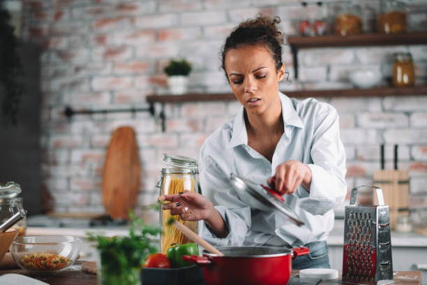 istock Beautiful woman preparing food in kitchen. 1223337537