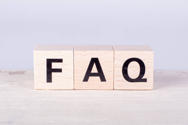istock wooden cubes building the word FAQ, white background and board 1223338764