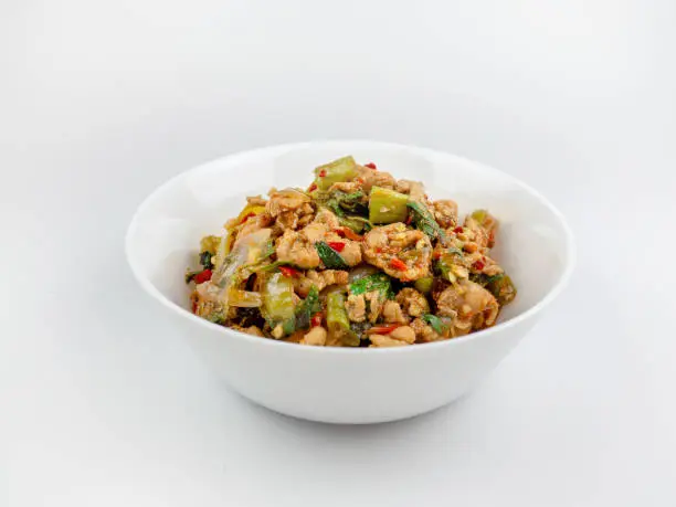 Photo of Stir-fried chicken with holy basil on white background., hot and spicy food