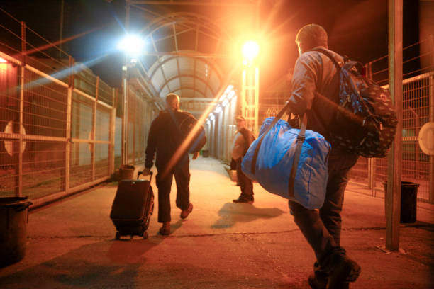Palestinian workers cross an checkpoint on their way to work in Israel . they carry belongings. Eyal border crossing, Qalqilya crossing between ISRAEL and PALESTINE, Qalqilya, West Bank, Palestinian Territories, Palestine - May 6, 2020