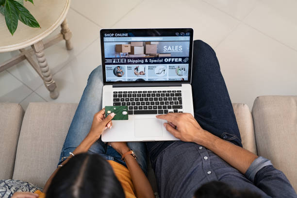 couples faisant des achats en ligne avec la carte de crédit - internet e commerce credit card retail photos et images de collection