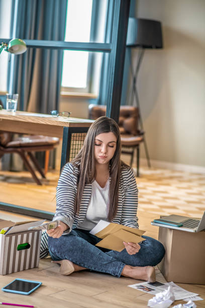 istock Young woman sitting on the floor and looking stressed 1223345929