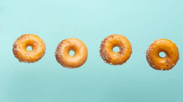 istock Falling donuts with chocolate on a light blue background. Freezing in motion, horizontal photo 1223346858