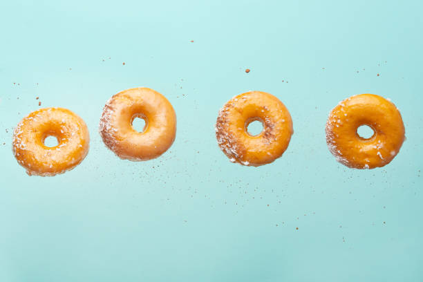 istock Falling donuts with chocolate on a light blue background. Freezing in motion, horizontal photo 1223347658