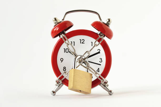 Alarm clock with chain and padlock on white background - Concept of time Alarm clock with chain and padlock on white background - Concept of time in bounds stock pictures, royalty-free photos & images