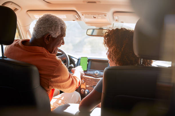 senior african american para na dysku przez wieś za pomocą nawigacji satelitarnej na telefon komórkowy - driving senior adult car women zdjęcia i obrazy z banku zdjęć
