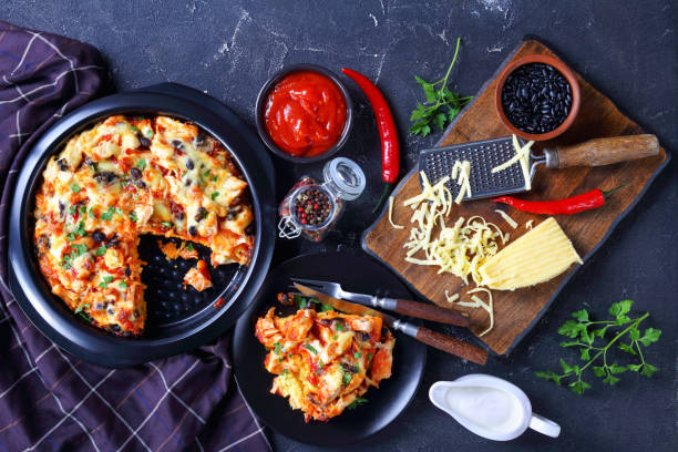 South american tamale pie of corn crust with tomato sauce, pulled chicken meat, cheddar cheese, black bean filling