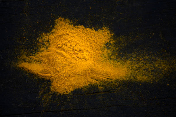 yellow curry spice on a black wooden background