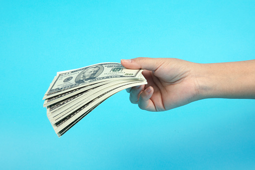 Female hand holding money banknotes.