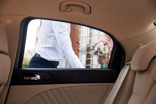 Bridegroom Opening Car Door For Bride.