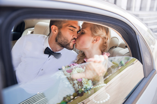 Husband and Wife Kissing on Back Seat of a Car.