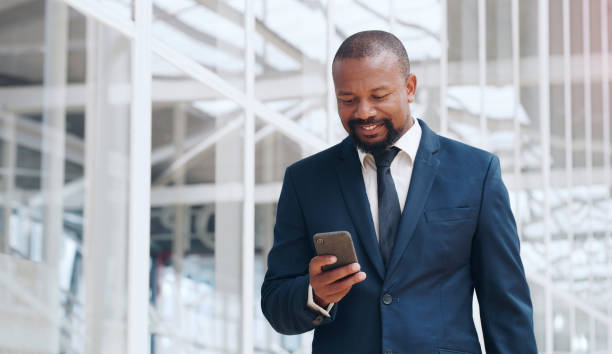 On the move and making success happen Shot of a mature businessman using a cellphone in an office businessman african descent on the phone business person stock pictures, royalty-free photos & images
