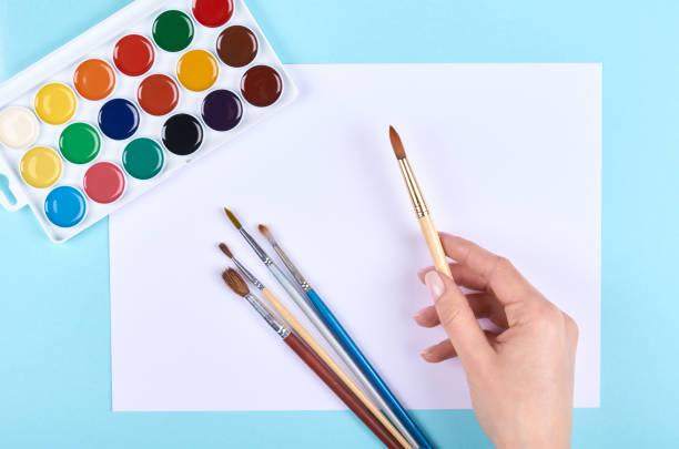 istock Watercolor paint and brushes on blue background. 1223358942