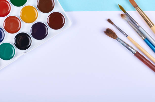 istock Watercolor paint and brushes on blue background. 1223358949