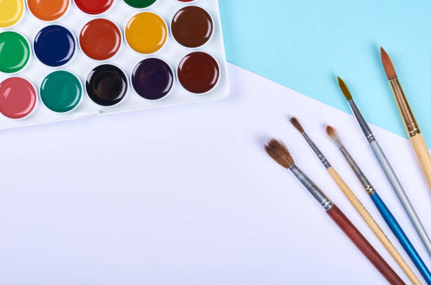 istock Watercolor paint and brushes on blue background. 1223358963